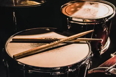 Aluno tocando bateria em aula na sede da associação