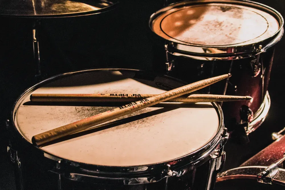 Aluno tocando bateria em aula na sede da associação